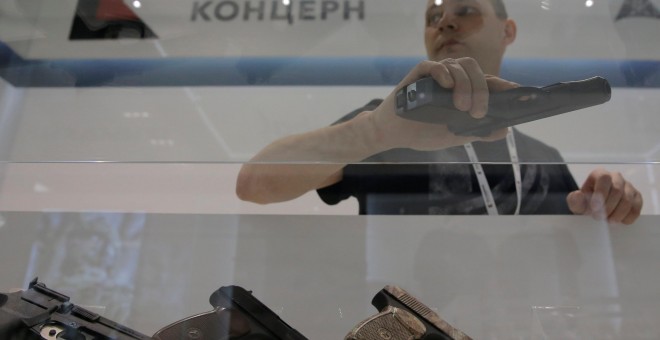 Un vendedor de armas sostiene una Kalashnikov/REUTERS