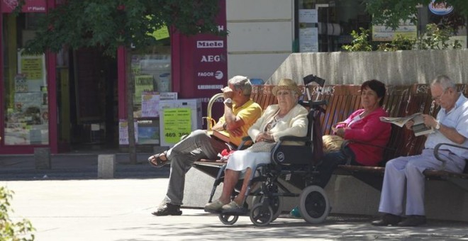 Varios pensionistas sentados en un banco. E.P.
