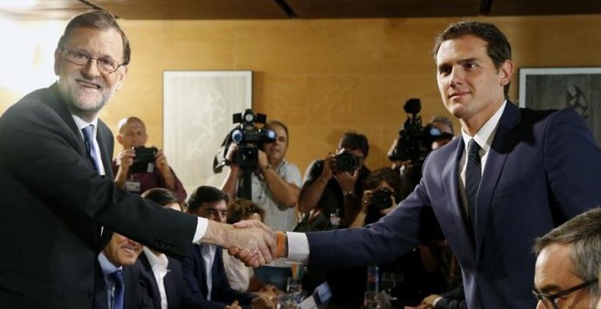 El jefe del Gobierno, Mariano Rajoy,iz., y el líder de Ciudadanos, Albert Rivera, se estrechan la mano durante la reunión de sus respectivas delegaciones en la que van a certificar el acuerdo de investidura-.EFE/Sergio Barrenechea