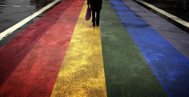 Un peatón pasa por una calzada pintada con los colores de la bandera gay arcoiris en la calle Oxford, de Sydney. REUTERS/David Gray
