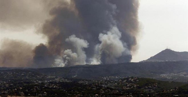 Vista general de la columna de humo del incendio que asola parte de los municipios alicantinos de Xábia y Benitatxell. EFE/Juan Carlos Cárdenas