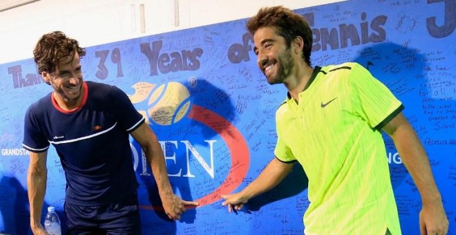 Feliciano López y Marc López posan en el muro de firmas del US Open tras ganar a los hermanos Bryan. /AFP