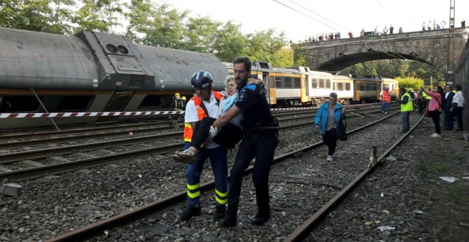 Policías y trabajadores trasladan a un herido tras el accidente en el que ha descarrilado un tren en O Porriño, Galicia. REUTERS/Vigoalminuto.com