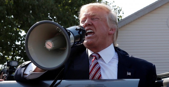 El candidato presidencial republicano Donald Trump habla a sus seguidores a través de un megáfono durante un acto de campaña en la Feria del Condado de Canfield en Canfield. REUTERS/Mike Segar