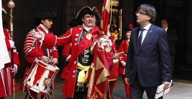 El presidente de la Generalitat, Carles Puigdemont (d), recibe a una representación de los Miquelets de Cataluña y de la Associació de Recreació Històrica La Coronela en el Palau de la Generalitat. /EFE