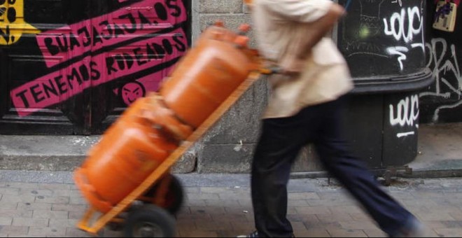Un trabajador traslada unas bombonas de butano. REUTERS