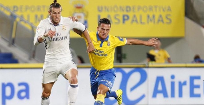 El centrocampista galés del Real Madrid Gareth Bale (i) disputa un balón con el centrocampista de la UD Las Palmas Roque Mesa (d).  EFE/Ángel Medina G.