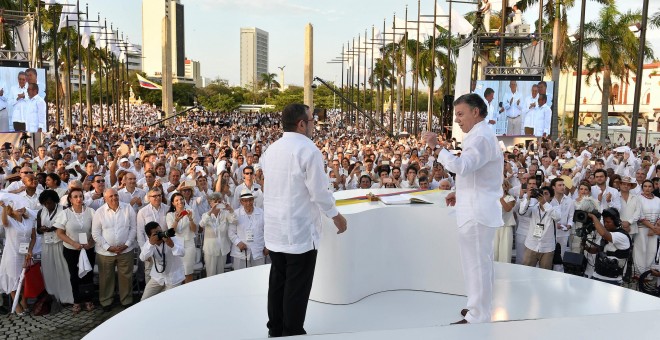 El presidente de Colombian, Juan Manuel Santos, y el líder de las FARC, Rodrigo Londoño Echeverri, 'Timochenko', tras la firma del acuerdo de paz en Cartagena de Indias. REUTERS