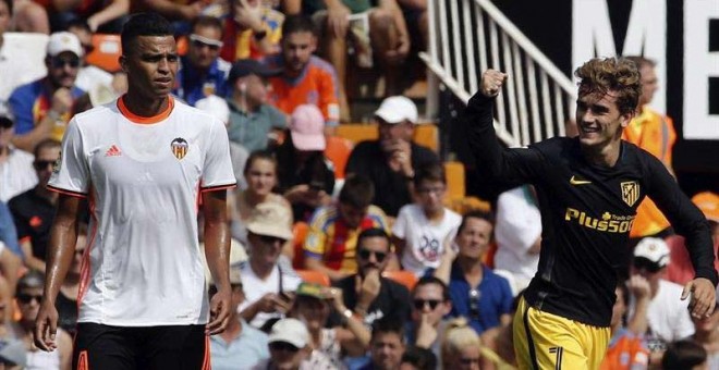 El delantero francés del Atlético de Madrid Antoine Griezmann (d), celebra el gol conseguido frente al Valencia, el del 0-1, en presencia del defensa brasileño del Valencia, Aderllan Santos. / EFE