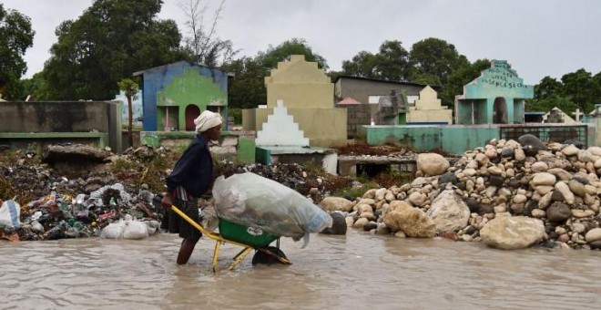 Una mujer empuja una carretilla en una calle inundada de Puerto Príncipe, Haití. - AFP