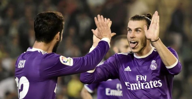 Los jugadores del Real Madrid, Isco (i) y el galés Gareth Bale, celebran el cuarto gol del equipo madridista, durante el encuentro correspondiente a la octava jornada de primera división, que disputan esta noche frente al Betis en el estadio Benito Villam