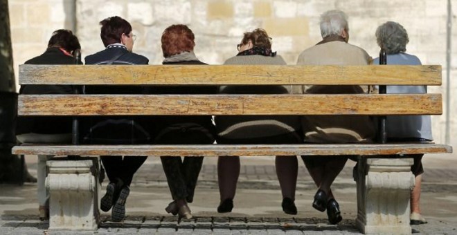 Varios pensionistas sentados en un banco en la localidad burgalesa de Briviesca. AFP