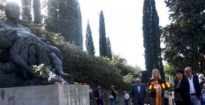 La consellera de la Presidencia y portavoz del Govern, Neus Munté (c), la directora general de Relaciones Institucionales con el Parlamento Carme Garcia (d), y el presidente de la Asociación Pro Memoria, Pere Fortuny (i), durante la ofrenda floral en el h