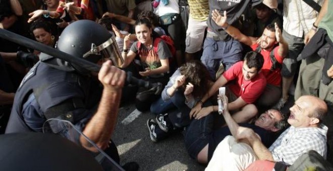 Varios agentes de Policía participan en el desalojo de la acampada de la plaza de Catalunya. REUTERS