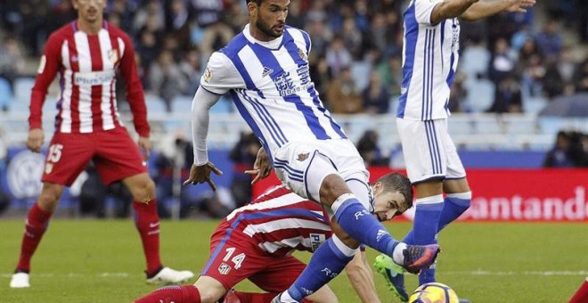 El centrocampista del Atlético de Madrid Gabi Fernández (i) disputa un balón con el delantero brasileño de la Real Sociedad Willian José (d), durante el partido de la undécima jornada de la Liga de Primera División que se juega hoy en el estadio de Anoeta