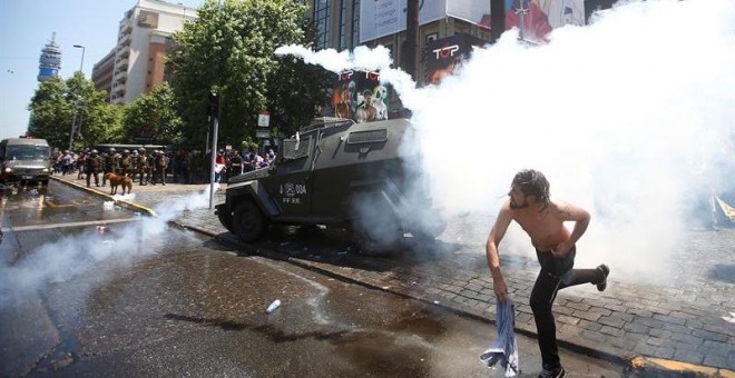 CH18. SANTIAGO (CHILE), 04/11/2016.- Un hombre se enfrenta con la policía hoy, viernes 4 de noviembre de 2016, en Santiago, donde decenas de miles de chilenos salieron a las calles para exigir el fin del sistema privado de pensiones vigente en el país, re