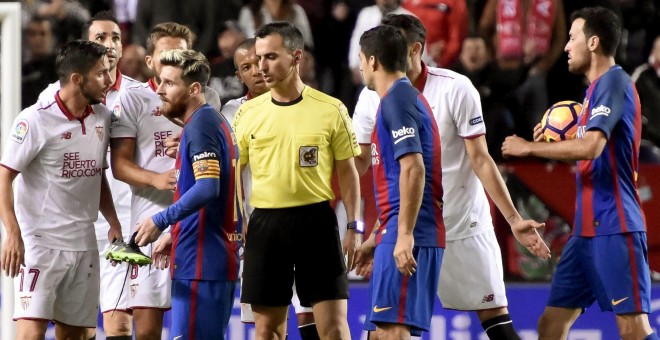 El delantero argentino del F. C. Barcelona, Leo Messi, abandona el terreno de juego después de que el árbitro le haya mostrado una tarjata amarilla por perde tiempo en el partido de liga disputado frente al Sevilla en el estadio Sánchez Pizjuán de la capi