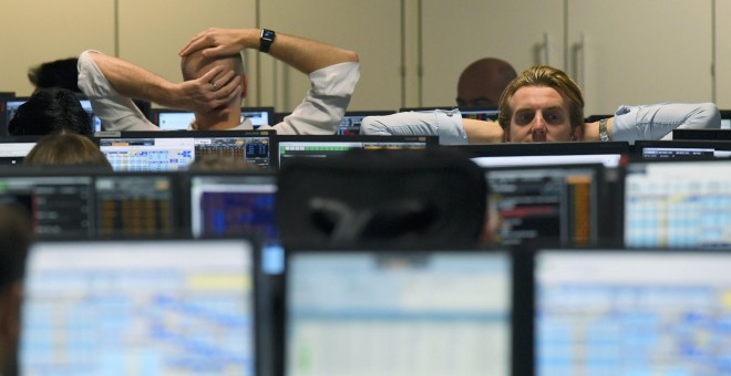 Operadores del mercado delante de sus pantallas en una firma de inversión en Londres. REUTERS