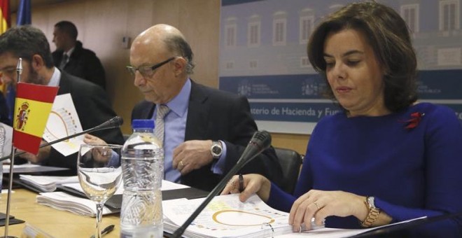 La vicepresidenta del Gobierno, Soraya Sáenz de Santamaría (d), y el ministro de Hacienda, Cristóbal Montoro (i), al inicio de la reunión del Consejo de Política Fiscal y Financiera que se celebra hoy en la sede del Ministerio en Madrid, en el que se deb