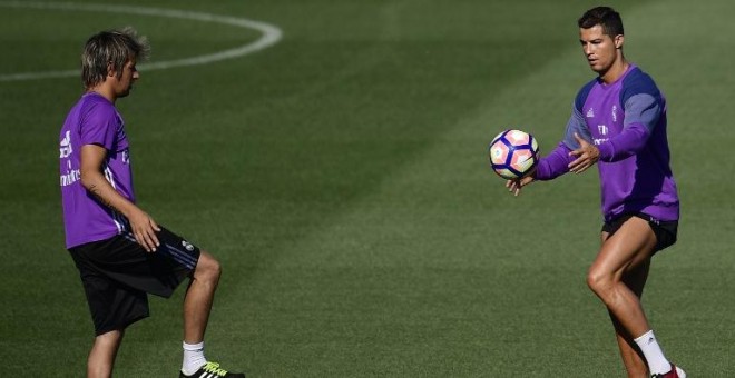 Los jugadores portugueses del Real Madrid Fabio Coentrao y Cristiano Ronaldo en un entrenamiento en Valdebebas. AFP / Pierre-Philippe Marcou