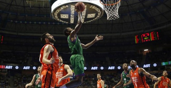 El base norteamericano del Unicaja JKyle Fogg (c) lanza a canasta tras zafarse de la defensa del alero del Valencia Basket Fernando San Emeterio este fin de semana. /EFE