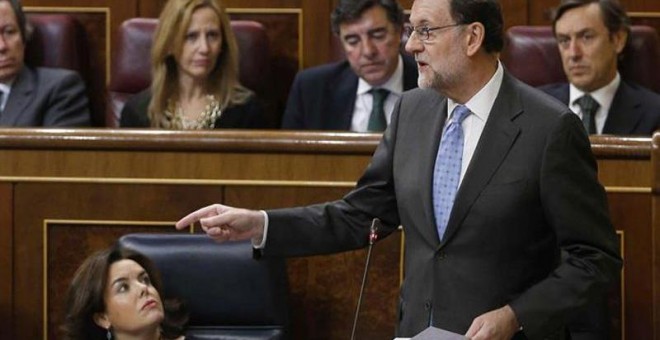 Mariano Rajoy responde a los diputados ante la mirada de la vicepresidenta. | PACO CAMPOS (EFE)