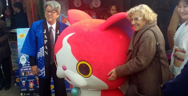 Manuela Carmena posando en la caseta de Japón con un muñeco. /J.Y.