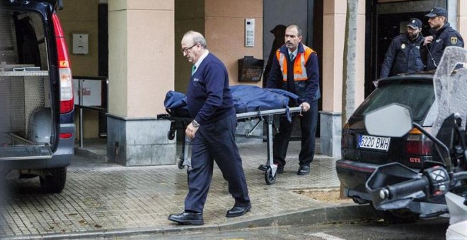 Miembros de los servicios funerarios trasladan los restos mortales de la mujer  fallecida en su piso del barrio de Son Cladera, en Palma. - EFE