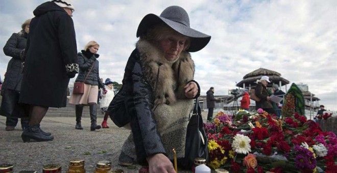 Una mujer enciende una vela en memoria de las víctimas del accidente del avión en el Mar Negro. | EFE