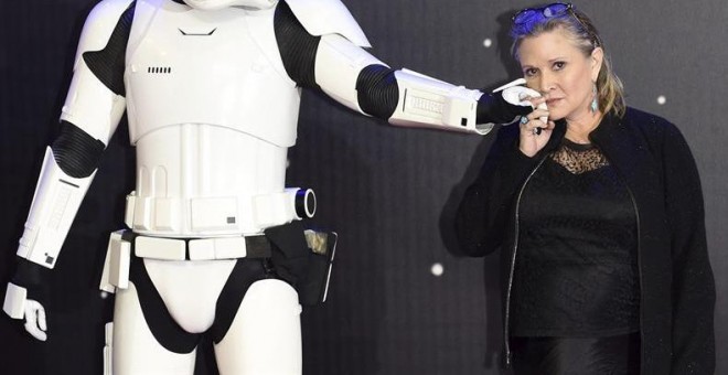 Fotografía de archivo del 16 de diciembre de 2015 que muestra a la actriz estadounidense Carrie Fisher posando junto a un personaje de la película durante el preestreno europeo de 'Star Wars: El Despertar de la Fuerza' en Londres, Reino Unido. La actriz e