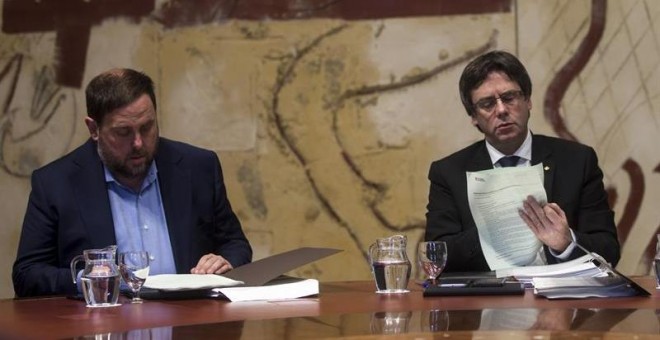 El president de la Generalitat, Carles Puigdemont (d), y el vicerpresidente del Govern y conseller de Economía, Oriol Junqueras (i), durante la última reunión ordinaria del año del ejecutivo catalán. /EFE
