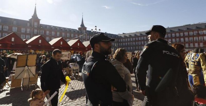 Una pareja de la Policía Nacional vigila en la Plaza Mayor de Madrid llena de gente en estas fechas navideñas. /EFE