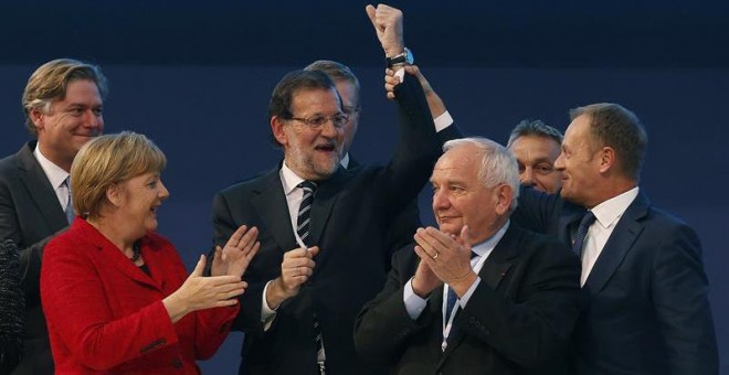 El presidente del Consejo Europeo, Donald Tusk (dcha.), levanta el brazo de Rajoy, junto al presidente el PPE, Joseph Daul (2dcha.), y Angela Merkel. EFE