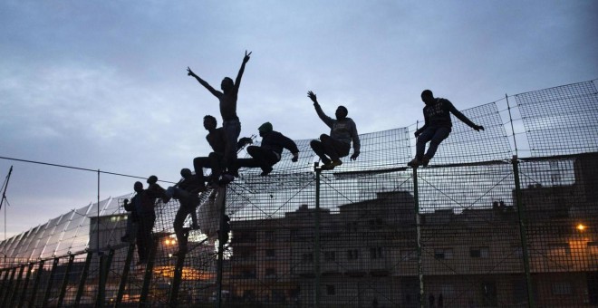 Inmigrantes intentan saltar la valla de Melilla. Archivo REUTERS (2014)