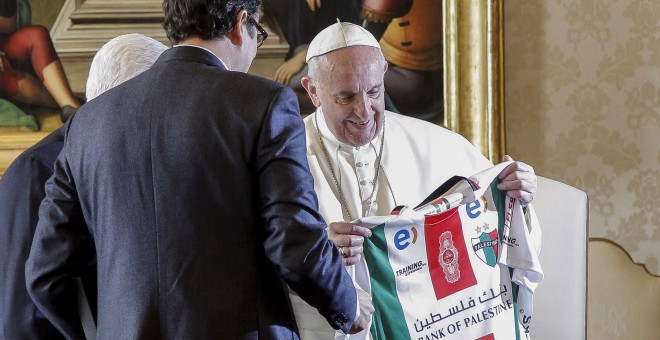 Un joven que entregó una camiseta de fútbol con los colores de la bandera palestina a Francisco. / REUTERS