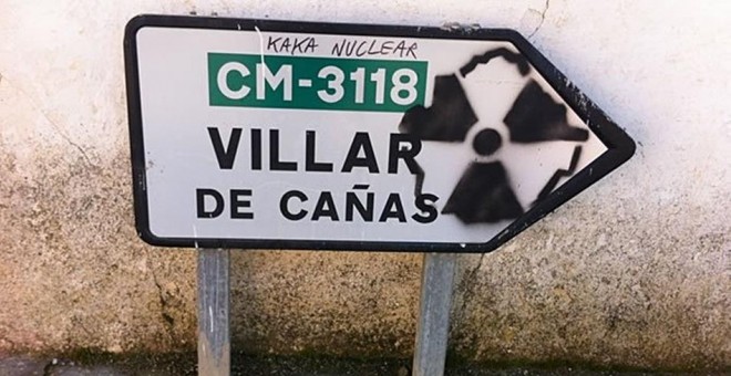 Una pintada contra el cementerio nuclear en un indicador de carrera de Villar de Cañas. EFE