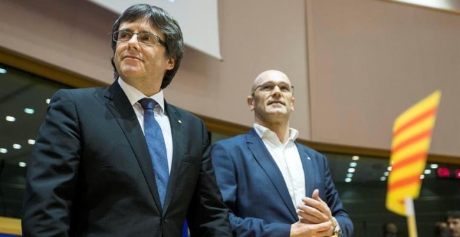 El presidente, Carles Puigdemont, y el conseller de Exteriores, Raül Romeva, durante la conferencia que han ofrecido en las instalaciones del Parlamento Europeo para explicar sus planes para convocar un referéndum sobre la independencia de Cataluña en Bru