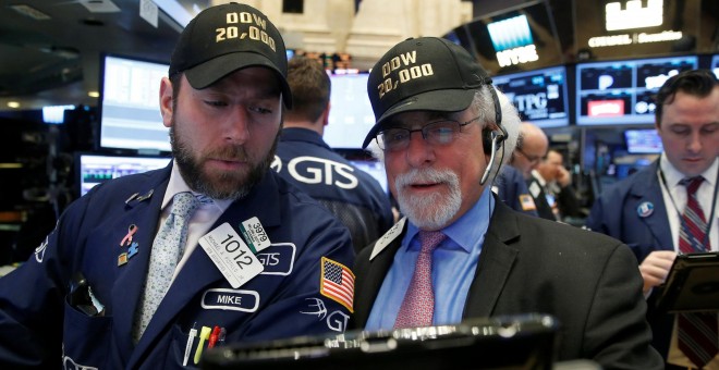 Dos operadores de la bolsa de Wall Street, con sendas gorras en la se lee el lema 'Dow 20.000', por el récord alcanzado por el principal indicador del mercado. REUTERS/Brendan McDermid