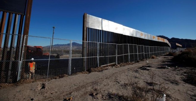 Un operario junto a una nueva sección de la valla de separación entre EEUU y México, cerca de Ciudad Juarez. - REUTERS
