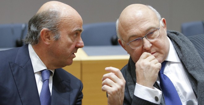 El ministro de Economía español, Luis de Guindos, conversa con el ministro de Finanzas francés, Michel Sapin, durante una reunión del Eurogrupo en Bruselas. EFE/Olivier Hoslet