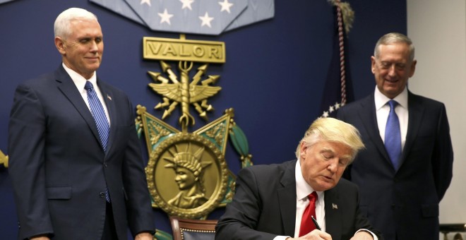 El presidente Donald Trump firma la orden que establece un control extremo de las personas que llegan a Estados Unidos después de asistir al juramento del secretario de Defensa, James Mattis (R), con el vicepresidente Mike Pence en Washington. REUTERS / C