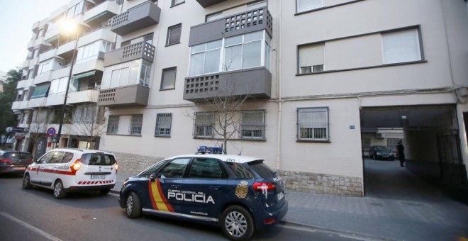 Un coche de Policía y otro de Cruz Roja en la entrada del edificio donde un matrimonio y su hija de 12 años han fallecido en Alicante, al parecer aplastados o asfixiados por cientos de kilos de ropa que acumulaban en su domicilio, después de que se desplo