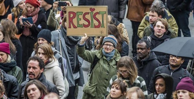 Protestas en todo el mundo. Un joven sujeta una pancarta durante una protesta contra Trump en Bruselas.- EFE