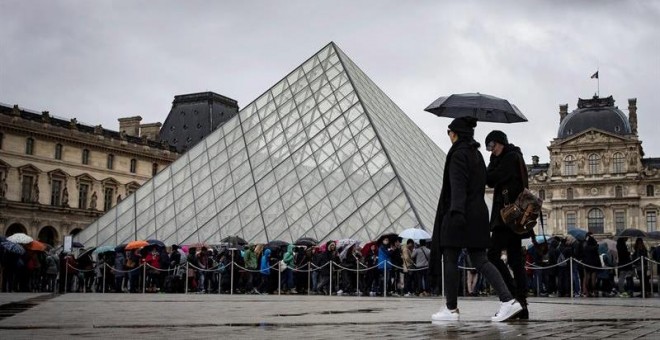 Turistas ante el museo del Louvre, en París. / IAN LANGSDON (EFE)