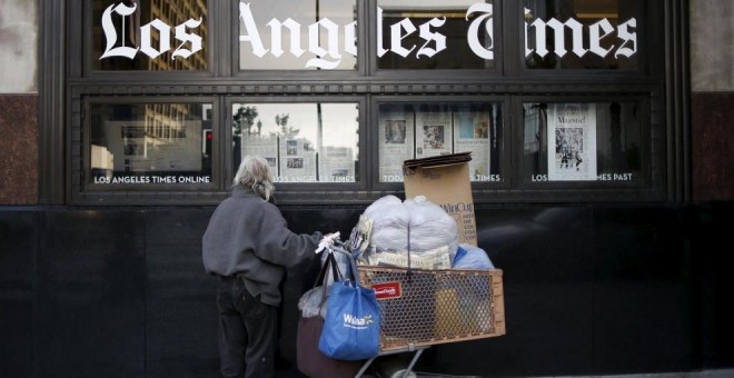 Un hombre lee el 'Los Angeles Times' mientras pasa por el edificio del propio. REUTERS