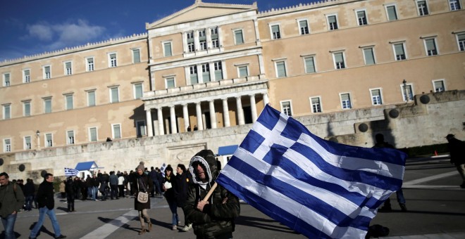 Un agricultor, con la bandera nacional griega, en la ateniense Plaza de Syntagma, donde está el Parlamento, tras una manifestación reclamando la bajada de impuestos.. REUTERS/Alkis Konstantinidis