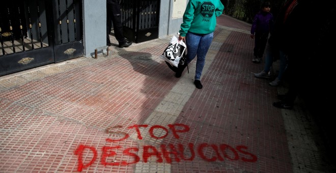 Una mujer abandona su domicilio en la localidad madrileña de Parla después de haber sido sesahuciada. REUTERS/Juan Medina