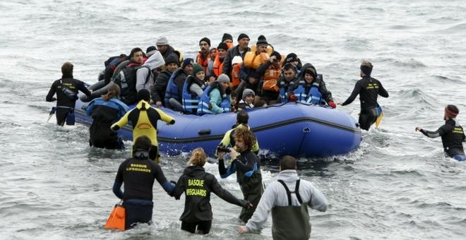 Un grupo de voluntarios acude a rescatar a los refugiados al llegar a la isla de Lesbos. REUTERS