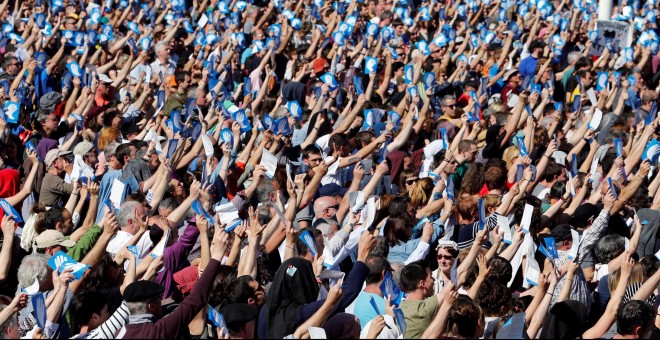 Una multitud de personas sostienen el símbolo de los llamados Artesanos de la Paz, los organizadores del desarme de ETA, en la concentración de Baiona. REUTERS / Regis Duvignau