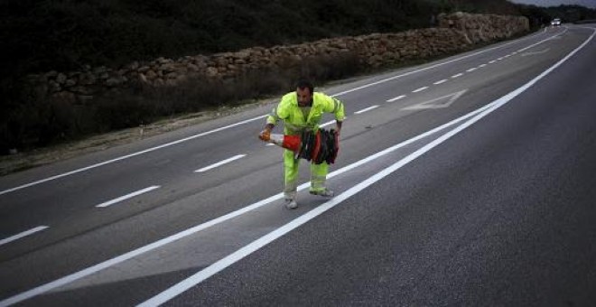 Trabajador colocando conos en una carretera de Ronda, Málaga./REUTERS